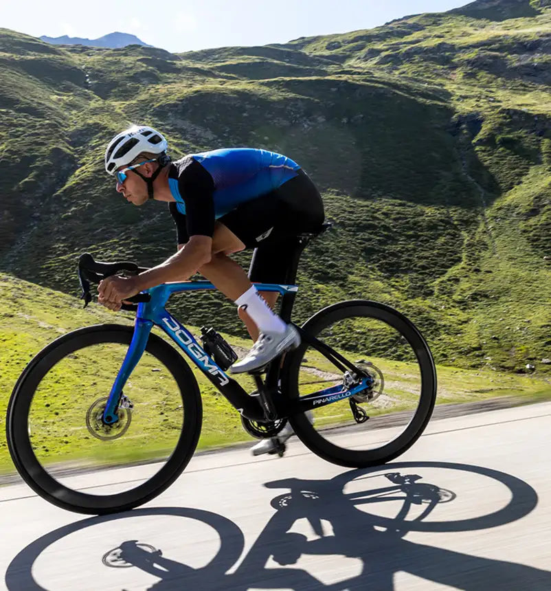 Cyclist on a blue bicycle in a mountainous landscape